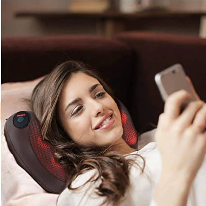 Woman relaxing on a sofa with the HaloRest massage pillow behind her neck
