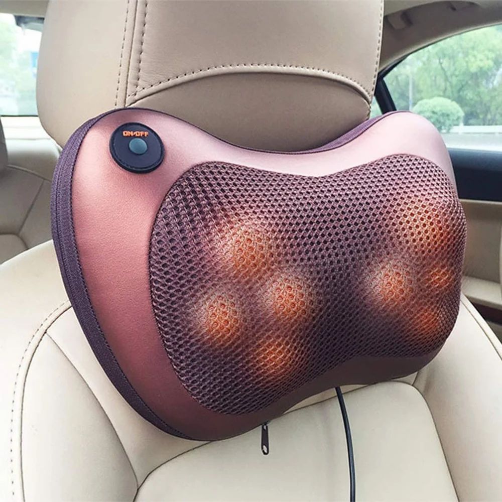 Brown shiatsu massage pillow fixed to a beige car headrest with its four nodes glowing orange